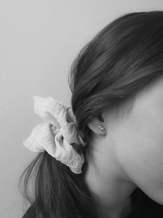 Záběr na ucho Moonchild dívky s Rozkošnými Rubari náušničkami - berušky v celozlatém provedení na šroubek na bílém pozadí jako symbol štěstí, něhy, hravosti a odhodlání.