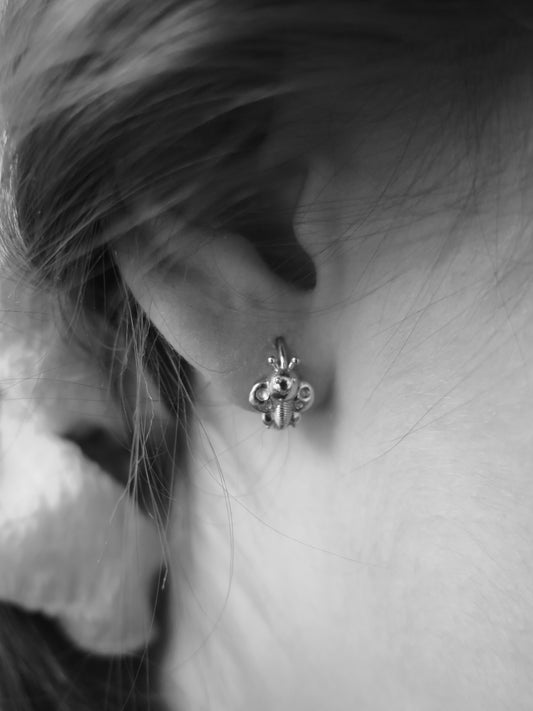 Půvabné první Rubari náušničky motýlci na uchu moonchild slečny v celozlatém provedení na moonfirst zapínání na bílém pozadí jako symbol lehkosti, hravosti a vnitřní přeměny. symbol jedinečnosti, individuality a vnitřní síly.